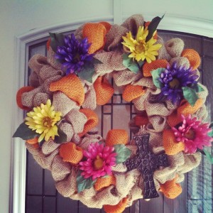 Spring/Summer wreath!! Beautiful brown burlap wreath with pops or orange burlap through out. It has added flowers for that extra color as well as an added cross!