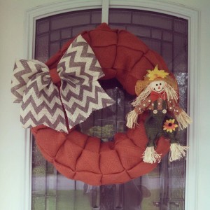 Burnt Orange burlap wreath with added grey and cream chevron bow and scarecrow