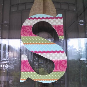 Multi-Colored Design Fabric Covered Letter. Letters are 13 1/2 inches tall with added decor piece and burlap hanger. Decor piece can be customized upon request!