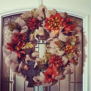 Beautiful Fall wreath. It is made with Natural Brown burlap with added fall leaves and flowers. It also has an added cross for decor.